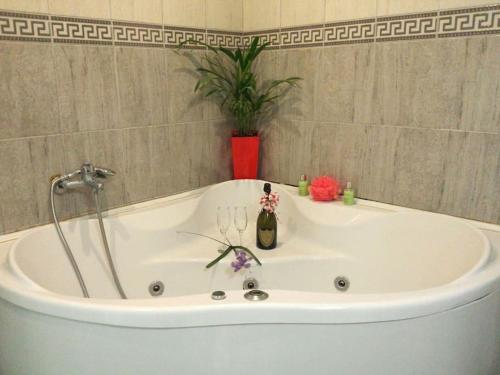 uma banheira com uma garrafa e 2 copos de vinho em 200 m2 Centre Penthouse Amazing Balcony em Belgrado