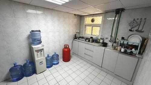 a kitchen with a fire extinguisher and water bottles at Dubai Zeus Hostel in Dubai