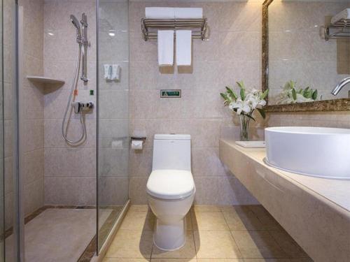 ein Bad mit einem WC, einem Waschbecken und einer Dusche in der Unterkunft Vienna Hotel Inner Mongolia Hohhot Railway Station Gongzhufu Metro Station in Hohhot
