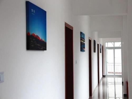 un corridoio con un mucchio di foto su un muro di Shell Linzhi Bayi Area G318 Shuangyong Road Hotel a Nyingchi