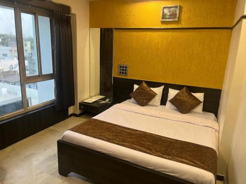 a bedroom with a large bed with a large window at Hotel Apple Inn in Ahmedabad
