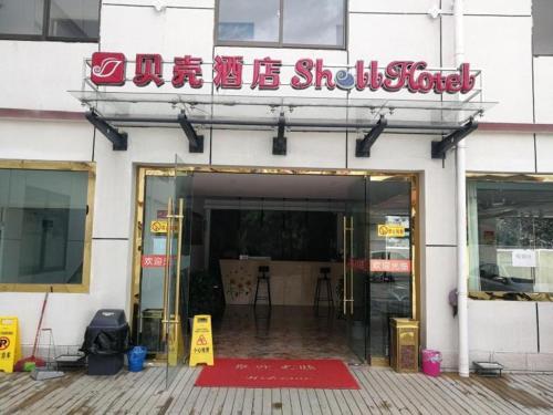 un bâtiment avec un panneau à l'avant dans l'établissement Shell Linzhi Bayi Area G318 Shuangyong Road Hotel, à Nyingchi