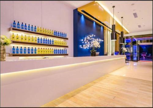 bar w sklepie z niebieskimi butelkami na ścianie w obiekcie Echarm Hotel Guiyang Longdongbao International Airport Outlets w mieście Guiyang