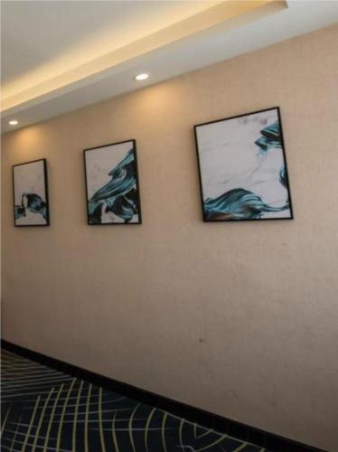 4 immagini incorniciate su un muro in una stanza di Borrman Hotel Hefei Guogou Plaza Sanli'an Metro Station a Hefei