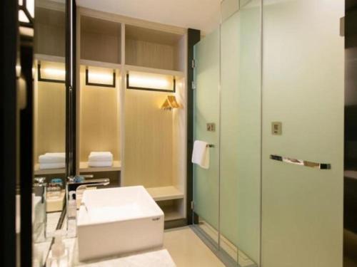 a bathroom with a sink and a mirror at Echarm Hotel Changchun Yiqi Automotive Trade City Wanda in Changchun