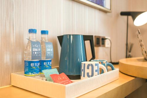 a tray with a coffee pot and bottles of water at Echarm Hotel Zibo Zhangdian District Government Polytechnic University Store in Zibo