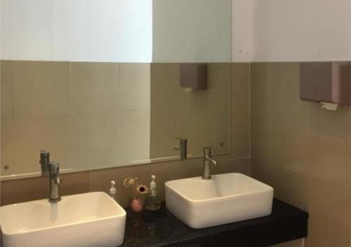 a bathroom with two sinks and a large mirror at Borrman Hotel Maoming Avenue Donghui City in Maoming
