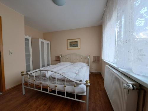 1 dormitorio con 1 cama blanca en una habitación en 3 Sterne FH Fürstenwalde, en Fürstenwalde