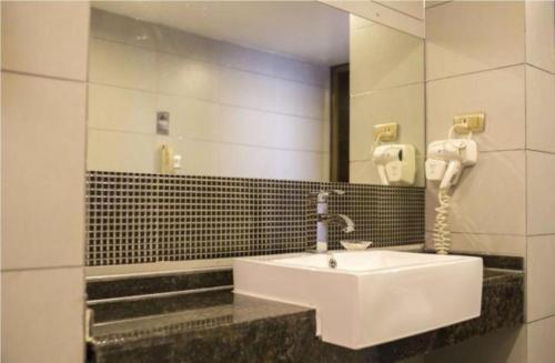 a bathroom with a white sink and a mirror at Borrman Hotel Liuzhou Ma'anshan Park Gubu Shopping Mall in Liuzhou