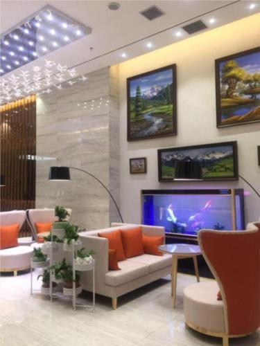 a living room with couches and a flat screen tv at City Comfort Inn Yi'Ning Jichang Road Shanghaicheng in Kipekyüzi