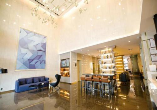 a living room with a blue couch and a bar at Echarm Hotel Changchun Guanggu Street in Changchun