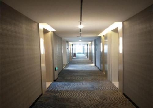 a hallway with a long corridor with a long hallway at Echarm Hotel Changchun Guanggu Street in Changchun