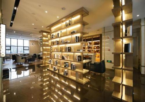 een kamer met een muur met een uitstalling van schoenen bij Echarm Hotel Changchun Guanggu Street in Changchun