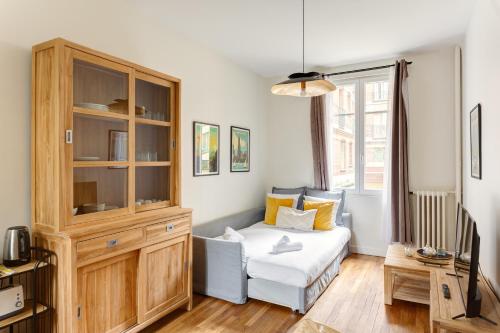 - une chambre avec un lit et une grande armoire en bois dans l'établissement Paris 15 Cocoon, à Paris