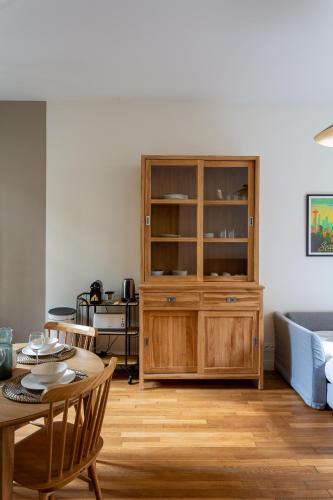 - un salon avec une armoire en bois et une table dans l'établissement Paris 15 Cocoon, à Paris