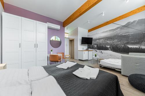 a bedroom with a bed with two towels on it at MEANDER THERMAL & SKI REZORT ORAVICE in Oravice