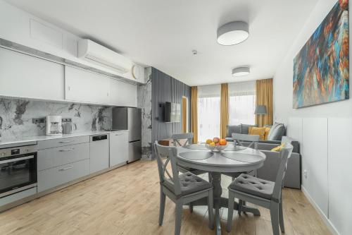 a kitchen and dining room with a table and chairs at Apartamenty Solaris in Darłówko