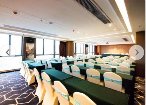 einen Konferenzraum mit weißen Stühlen und Schreibtischen in der Unterkunft Echeng Hotel Sanming City Government RT-Mart in Sanming