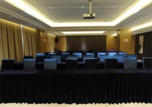 une salle de conférence avec des chaises bleues et un écran dans l'établissement Echeng Hotel Beihai Hunan Road Old Street, à Gaode