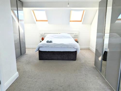 a bedroom with a bed in a room with skylights at Beautiful 4 Bed Portsmouth Home Bright & Modern with Garden & Free Parking & Spa Bath & Fully Equiped Kitchen Perfect For Work or The Family in Portsmouth