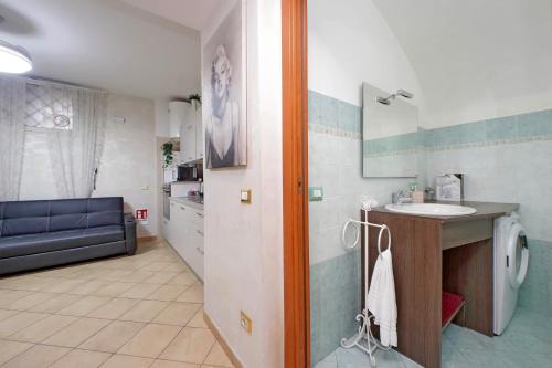 łazienka z umywalką i kanapą w pokoju w obiekcie Gallery Home w Rzymie