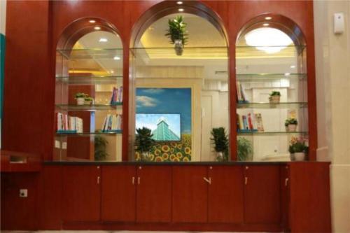 Zimmer mit einer Bibliothek mit Regalen und Fenstern in der Unterkunft City Comfort Inn Shenzhen Longhua Guanlan Metro Station in Tiantangwei