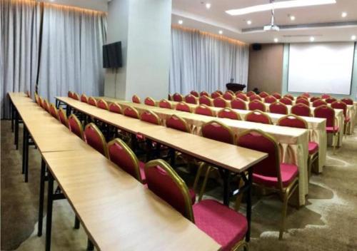 a room with rows of tables and red chairs at Borrman Hotel Liuzhou Guizhong Avenue Liugao in Liuzhou