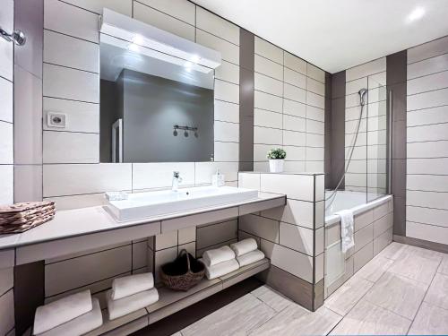 a white bathroom with a sink and a mirror at Appartements en Centre Ville de Bordeaux in Bordeaux