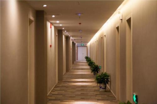 un corridoio di un edificio con piante di JTOUR Inn Changzhou Wanda Plaza Railway Station a Changzhou