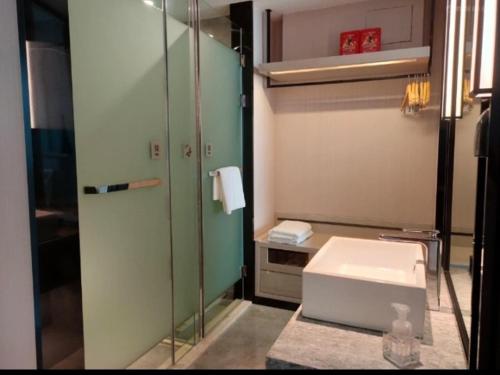 a bathroom with a toilet and a glass shower at Echarm Hotel Heze Renmin Road Peony Garden Railway Station in Heze