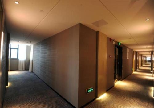 an empty hallway of an office building with a wall at Echarm Hotel Nanning Chaoyang Square River View in Nanning