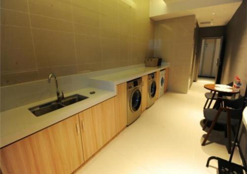a kitchen with a sink and a washing machine at Echarm Hotel Nanning Chaoyang Square River View in Nanning
