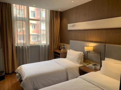 um quarto de hotel com duas camas e uma janela em JTOUR Inn Huangshi North Station Cihu Scenic Area em Huangshi