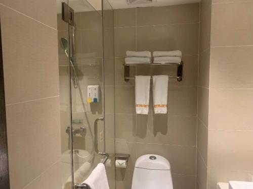 uma casa de banho com chuveiro, WC e toalhas em JTOUR Inn Huangshi North Station Cihu Scenic Area em Huangshi