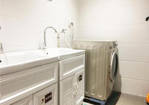 łazienka z umywalką i pralką w obiekcie JTOUR Inn Huangshi North Station Cihu Scenic Area w mieście Huangshi