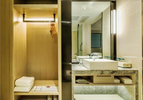 a bathroom with a sink and a mirror at Echarm Hotel Anshun High-speed Railway Station Jichang Road in Anshun