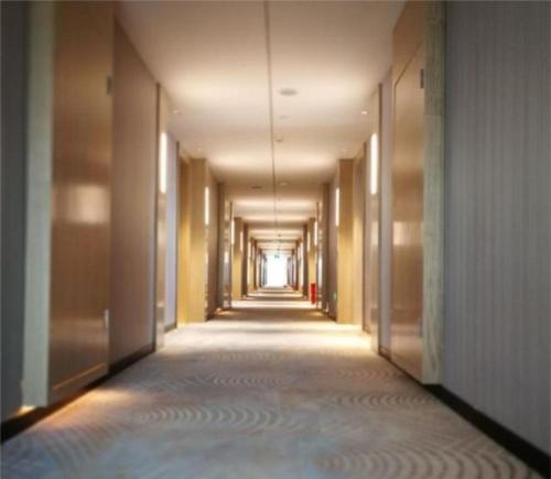 un couloir vide avec un long couloir dans l'établissement Echarm Hotel Nanning Baisha Avenue Shizhuling Metro Station, à Nanning