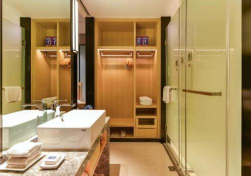 y baño con lavabo y ducha. en Echarm Hotel Nanning Baisha Avenue Shizhuling Metro Station en Nanning