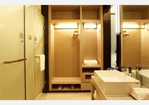 uma casa de banho com um lavatório, um chuveiro e um WC. em Echarm Hotel Liuzhou Liunan Wanda Plaza em Liuzhou