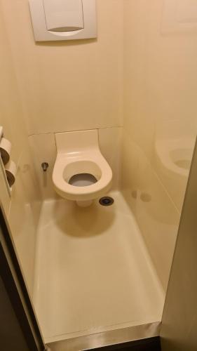a small bathroom with a toilet and a bath tub at ibis budget Poitiers Nord Futuroscope in Chasseneuil-du-Poitou