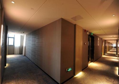 um corredor vazio de um edifício de escritórios com uma parede em Echarm Hotel Guilin High-tech Wanda Li Lake em Guilin