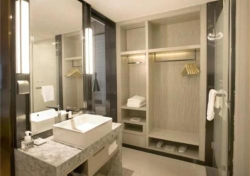 uma grande casa de banho com um lavatório e um chuveiro em Echarm Hotel Guilin High-tech Wanda Li Lake em Guilin