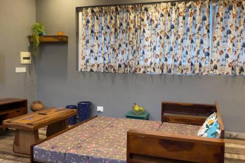 a bedroom with a bed and a window with a curtain at Aristaa Morni Hills: Pristine Stay in the Wild in Morni