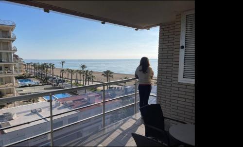 une femme debout sur un balcon donnant sur l'océan dans l'établissement Apartamentos-Atico Reformados Pompeya I y II, à Peñíscola