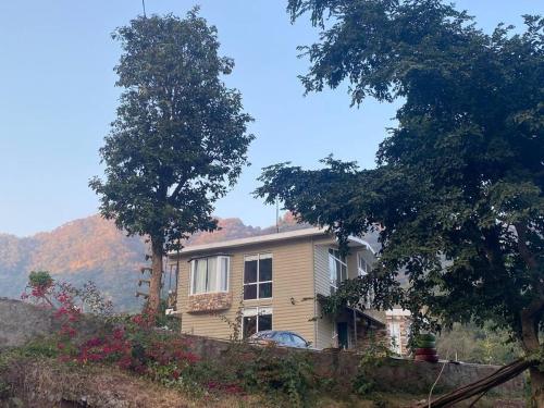 a house sitting on top of a hill with trees at Aristaa Morni Hills: Pristine Stay in the Wild in Morni