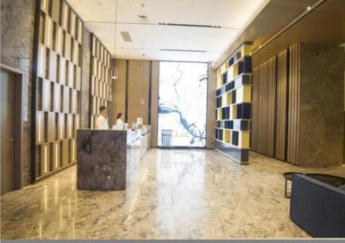 a lobby with a reception desk in a building at Echarm Hotel Beihai Yintan in Dianbailiao
