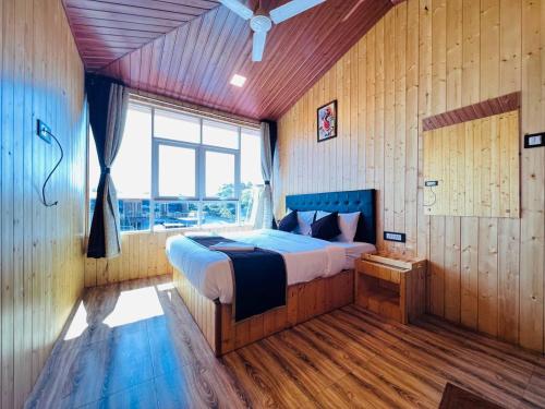 a bedroom with a bed and a large window at Arya's Village in Mahabaleshwar