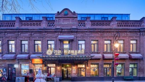 an old brick building with a balcony on top of it at Floral Hotel Birch's Story Harbin in Harbin