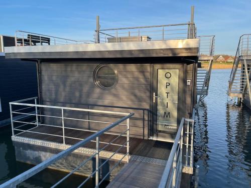 a small boat is docked in the water at Hausboot Optima in Wangerland