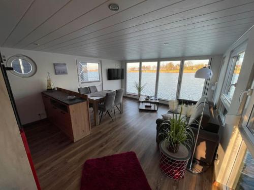 a living room with a table and a desk in a boat at Hausboot Optima in Wangerland